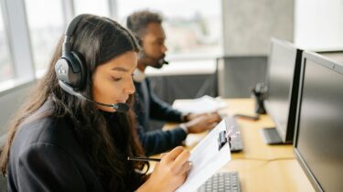 To mennesker passer telefon og Live Chat for Topcall